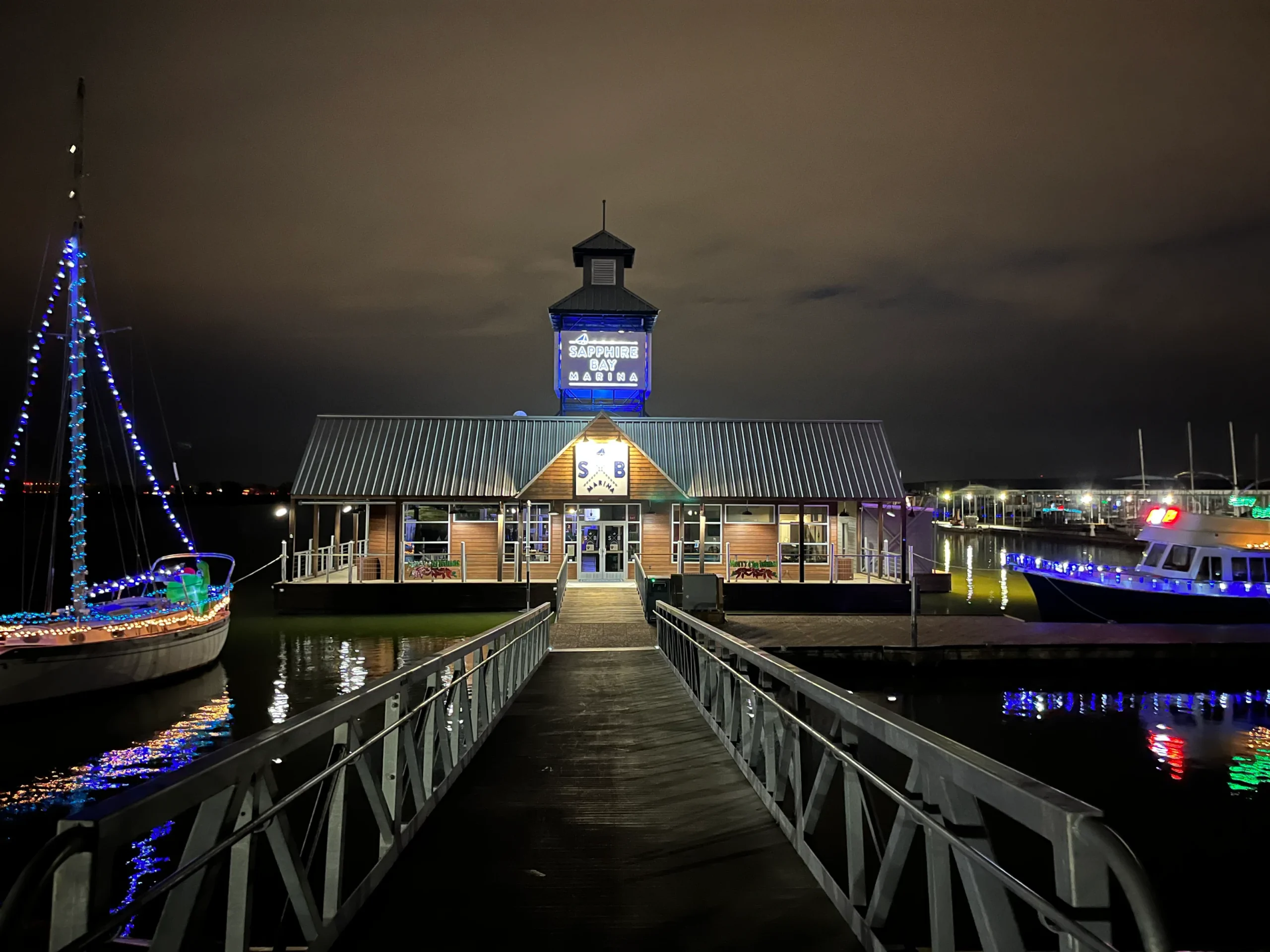 Entrance to Sapphire Bay Marina at night with a boat
